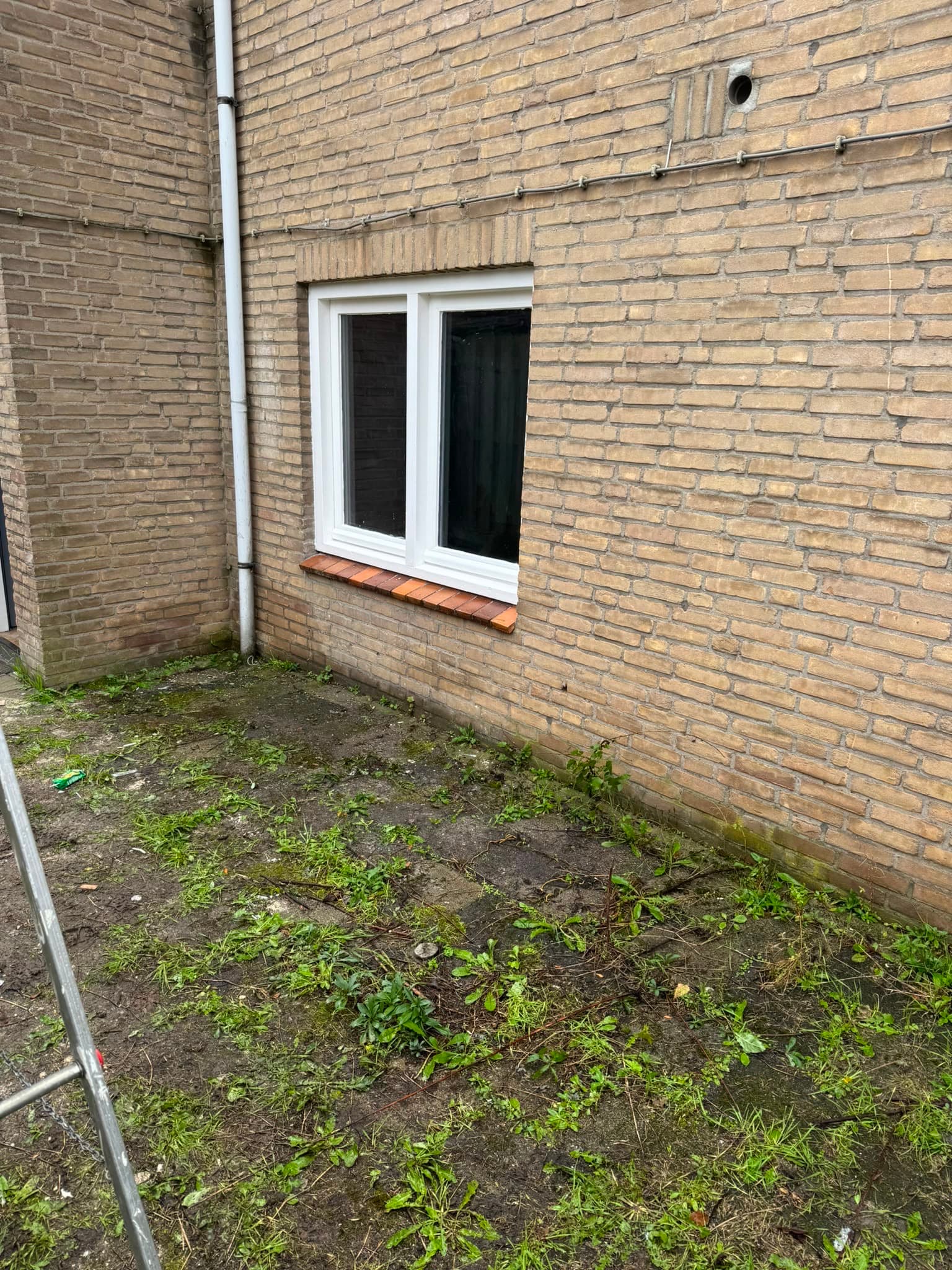 Nieuw geplaatst raamkozijn in een bakstenen buitenmuur