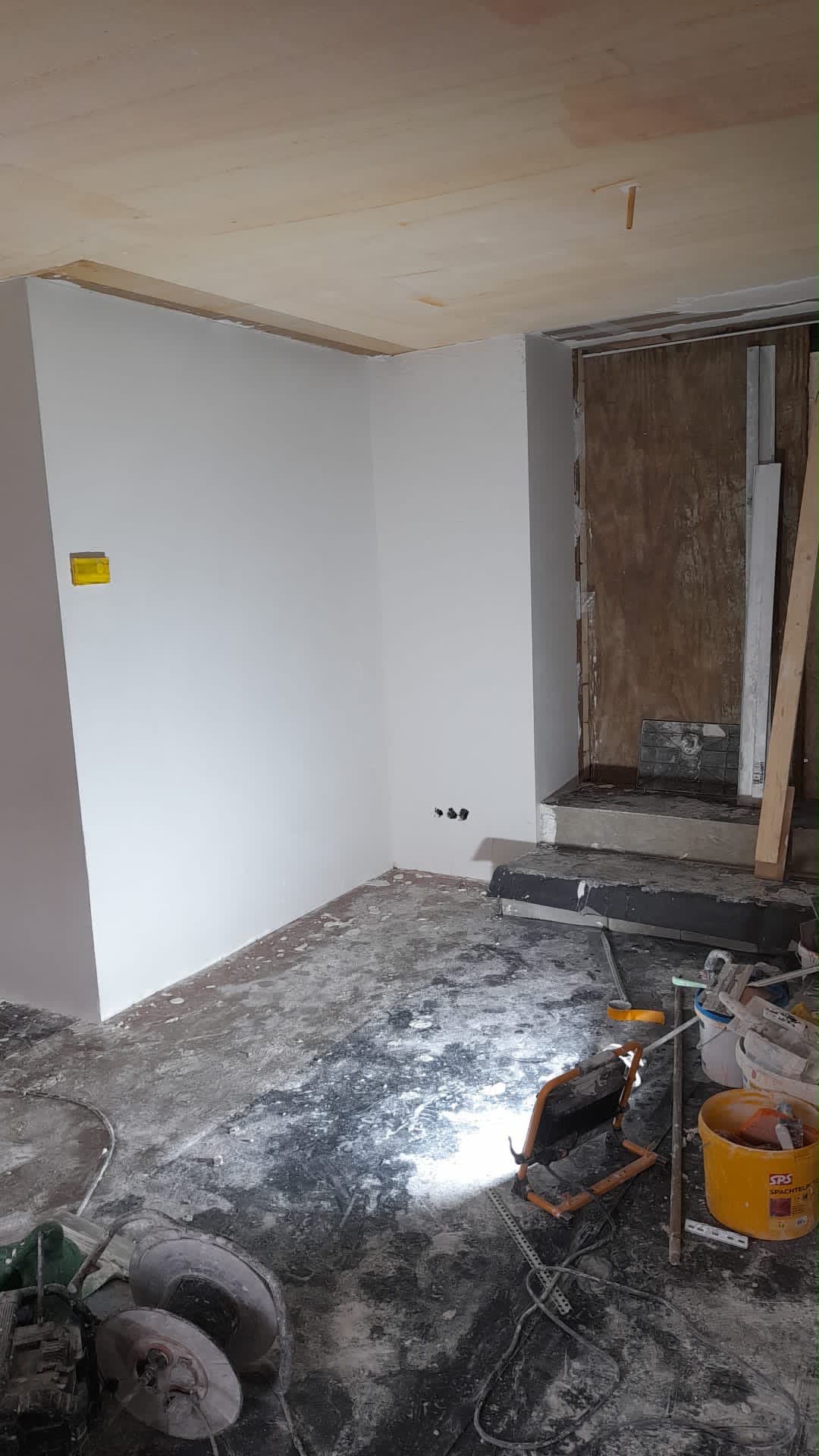 Nieuwe gladde wand naast een uit te breken oude muur